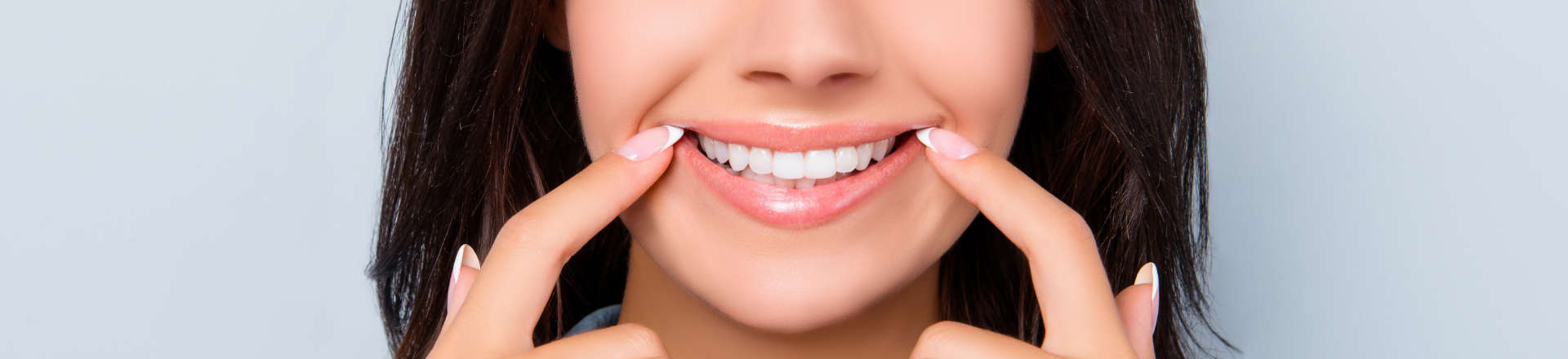 woman pointing at her nice teeth after dental cosmetic treatments